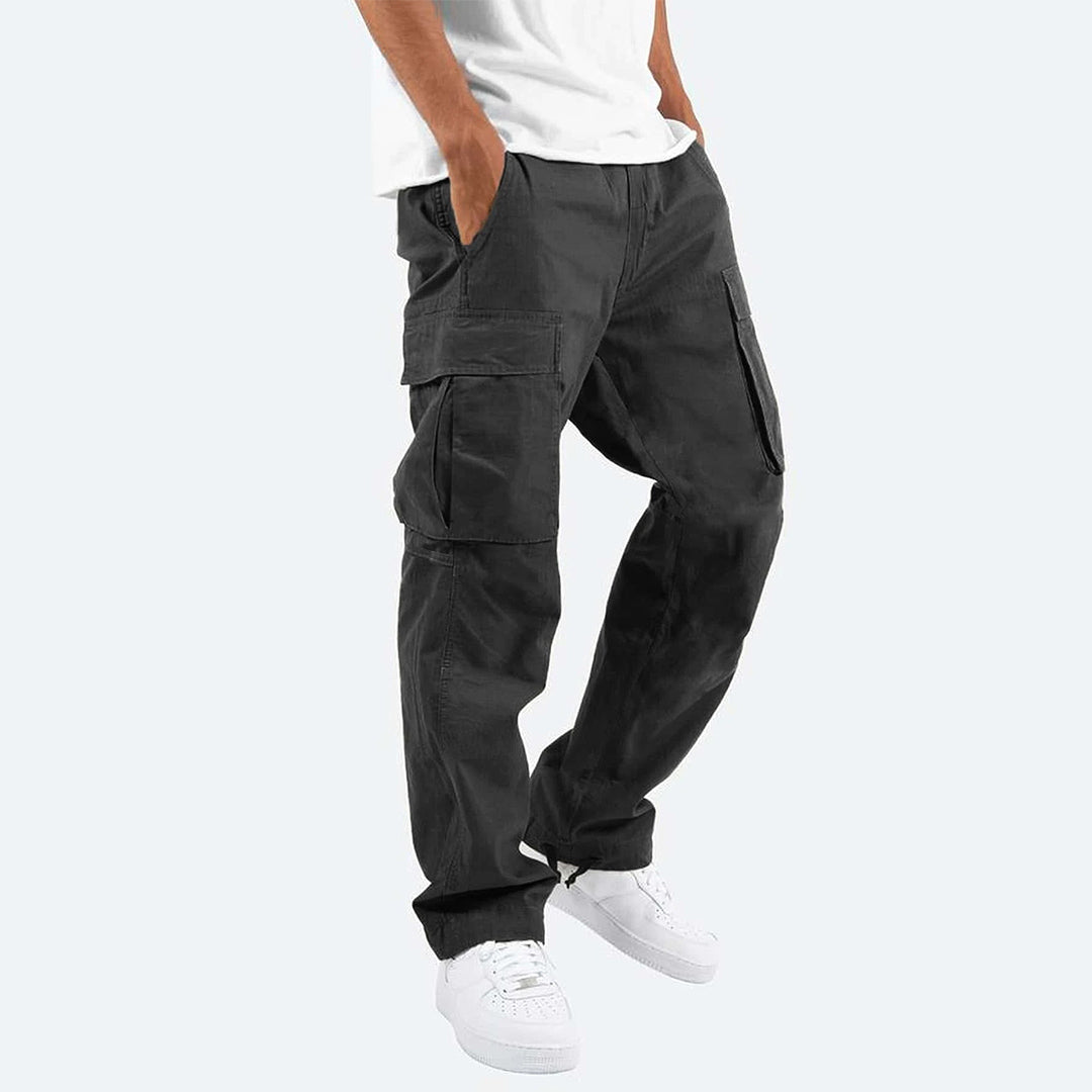 Grijze cargobroek voor heren, Ryker model, met meerdere zakken, casual streetwear stijl, gecombineerd met witte sneakers en een wit T-shirt.