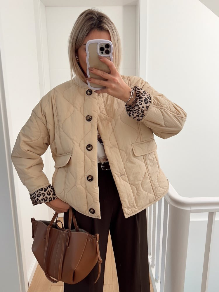 Veste élégante, coupe ajustée. Doublure léopard discrète. Chic et moderne.